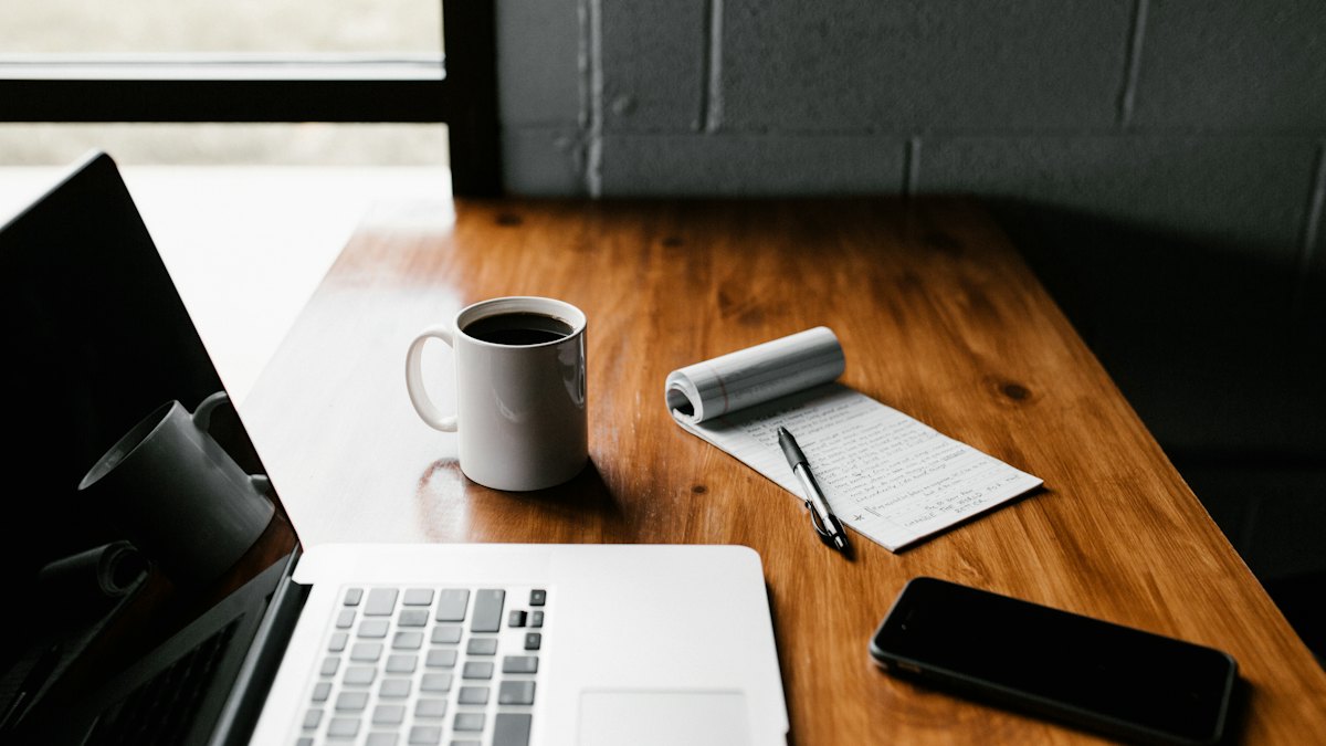 A laptop and coffee on a work desk