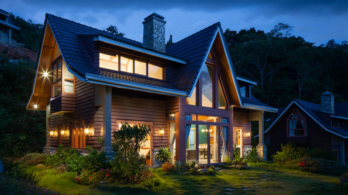 A modern house lit up at dusk