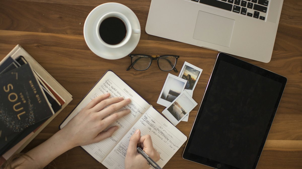 A notebook, tablet and coffee on a desk