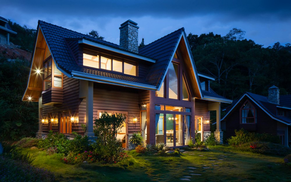 A modern house lit up at dusk